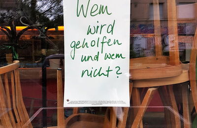 Note dans la vitrine du restaurant "Qui est aidé et qui ne l'est pas ?"